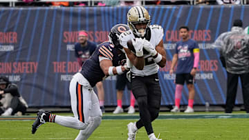 Oct 19, 2025; Chicago, Illinois, USA; New Orleans Saints wide receiver Chris Olave (12) runs with the ball after making a catch against Chicago Bears cornerback Kyler Gordon (6) during the first half at Soldier Field. Mandatory Credit: David Banks-Imagn Images
