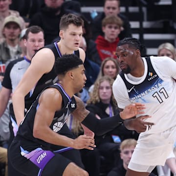 Feb 28, 2025; Salt Lake City, Utah, USA; Minnesota Timberwolves center Naz Reid (11) drives against Utah Jazz forward KJ Martin (99) and center Walker Kessler (24) during the second quarter at Delta Center. Mandatory Credit: Rob Gray-Imagn Images