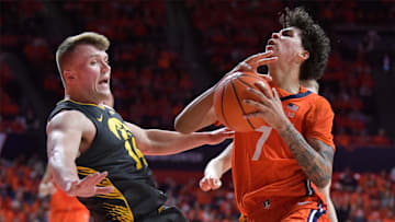 Feb 25, 2025; Champaign, Illinois, USA;  Illinois Fighting Illini forward Will Riley (7) drives the ball against Iowa Hawkeyes guard Carter Kingsbury (14) during the first half at State Farm Center. Mandatory Credit: Ron Johnson-Imagn Images