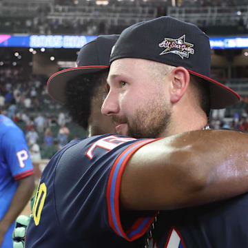 Seattle Mariners catcher Cal Raleigh (29) gets a hug from Tampa Bay Rays infielder Junior Caminero (13) after Raleigh wins the 2025 Home Run Derby at Truist Park on July 14. 