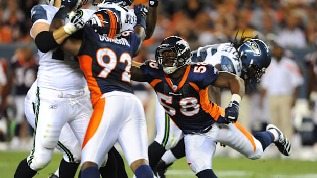 Denver Broncos linebacker Von Miller (58) and defensive end Elvis Dumervil (92) combine for a sack.