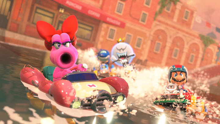 Birdo, King Boo, and Mario racing in water-based vehicles in Mario Kart World.