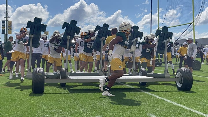 Packers players attack a five-man sled at training camp on Aug. 6.