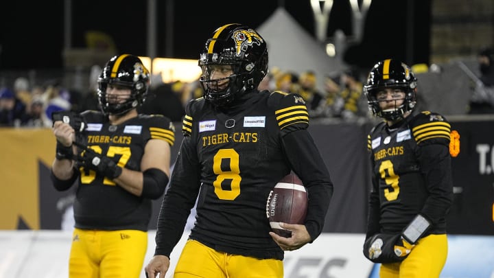 Dec 12, 2021; Hamilton, Ontario, CAN; Hamilton Tiger-Cats quarterback Jeremiah Masoli (8) and offensive lineman Jesse Gibbon (67) and quarterback Dane Evans (9) during warmup for the 108th Grey Cup football game against the Winnipeg Blue Bombers at Tim Hortons Field. Mandatory Credit: John E. Sokolowski-USA TODAY Sports