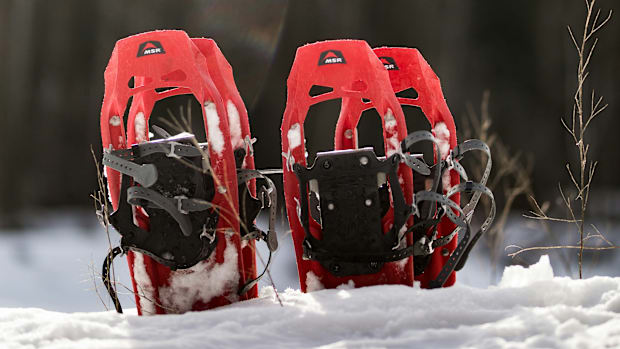 Red snowshoes stuck in the snow.