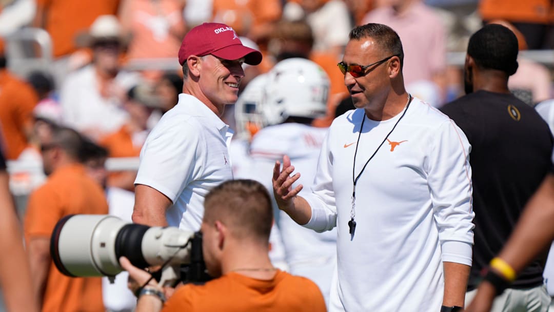 Oklahoma coach Brent Venables talks with Texas coach Steve Sarkisian before the Red River Rivalry college football game between the Oklahoma Sooners and the Texas Longhorns.