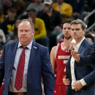 Wisconsin Badgers head coach Greg Gard (left) walks onto the court during a time out in the first half of the 2025 TIAA Big Ten Men’s Basketball Tournament final game against the Michigan Wolverines on Sunday, March 16, 2025, at Gainbridge Fieldhouse in Indianapolis. 