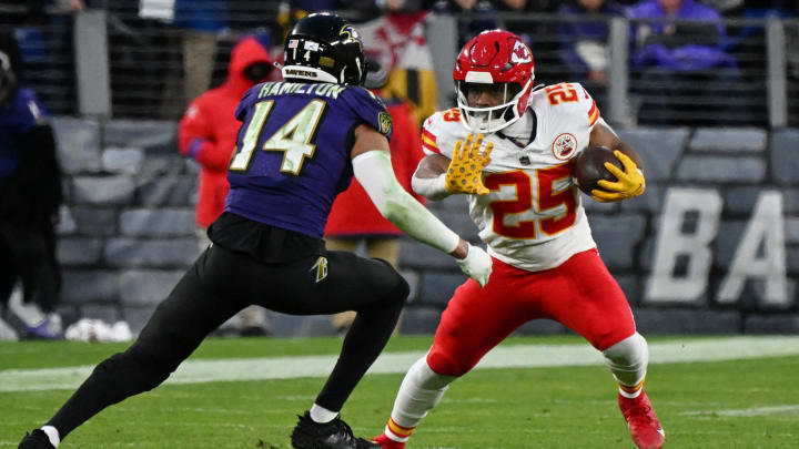 Jan 28, 2024; Baltimore, Maryland, USA; Kansas City Chiefs running back Clyde Edwards-Helaire (25) runs with the ball against Baltimore Ravens safety Kyle Hamilton (14) during the second half in the AFC Championship football game at M&T Bank Stadium. Mandatory Credit: Tommy Gilligan-USA TODAY Sports