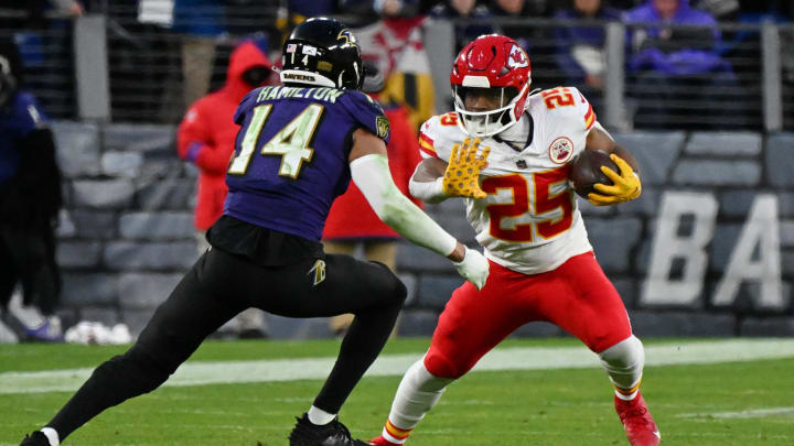 Jan 28, 2024; Baltimore, Maryland, USA; Kansas City Chiefs running back Clyde Edwards-Helaire (25) runs with the ball against Baltimore Ravens safety Kyle Hamilton (14) during the second half in the AFC Championship football game at M&T Bank Stadium. Mandatory Credit: Tommy Gilligan-USA TODAY Sports