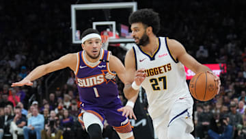 Feb 8, 2025; Phoenix, Arizona, USA; Denver Nuggets guard Jamal Murray (27) dribbles against Phoenix Suns guard Devin Booker (1) during the second half at Footprint Center. Mandatory Credit: Joe Camporeale-Imagn Images