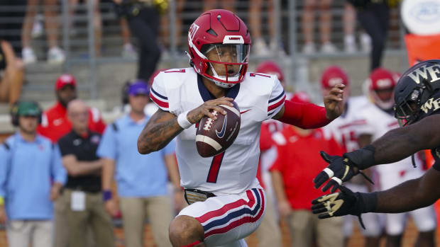 Liberty Flames quarterback Kaidon Salter runs with the ball during a college football game.