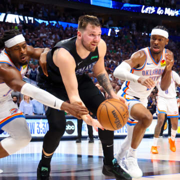 May 18, 2024; Dallas, Texas, USA;  Dallas Mavericks guard Luka Doncic (77) passes the ball as Oklahoma City Thunder guard Luguentz Dort (5) and Oklahoma City Thunder guard Shai Gilgeous-Alexander (2) during the second half in game six of the second round of the 2024 NBA playoffs at American Airlines Center. Mandatory Credit: Kevin Jairaj-USA TODAY Sports