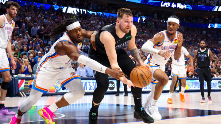 May 18, 2024; Dallas, Texas, USA;  Dallas Mavericks guard Luka Doncic (77) passes the ball as Oklahoma City Thunder guard Luguentz Dort (5) and Oklahoma City Thunder guard Shai Gilgeous-Alexander (2) during the second half in game six of the second round of the 2024 NBA playoffs at American Airlines Center. Mandatory Credit: Kevin Jairaj-USA TODAY Sports