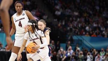 Former South Carolina basketball star Destanni Henderson uses a screen from teammate Aliyah Boston to get around UConn's Paige Bueckers in the 2021-2022 National Championship Game.