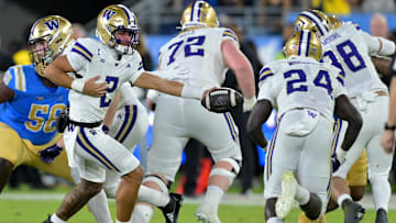 Nov 22, 2025; Pasadena, California, USA;  Washington Huskies quarterback Demond Williams Jr. (2) hands off to running back Adam Mohammed (24) during the first half against the UCLA Bruins at the Rose Bowl. Mandatory Credit: Jayne Kamin-Oncea-Imagn Images