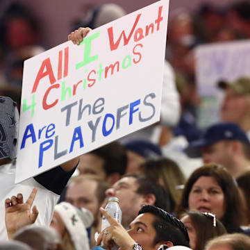 A Dallas Cowboys fan holds up a sign wanting playoffs for Christmas during the game against the Los Angeles Rams. 