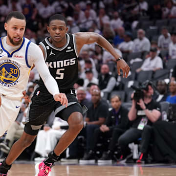 Apr 15, 2023; Sacramento, California, USA; Golden State Warriors guard Stephen Curry (30) dribbles past Sacramento Kings guard De'Aaron Fox (5) in the third quarter during game one of the 2023 NBA playoffs at the Golden 1 Center. Mandatory Credit: Cary Edmondson-Imagn Images