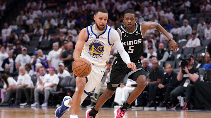 Apr 15, 2023; Sacramento, California, USA; Golden State Warriors guard Stephen Curry (30) dribbles past Sacramento Kings guard De'Aaron Fox (5) in the third quarter during game one of the 2023 NBA playoffs at the Golden 1 Center. Mandatory Credit: Cary Edmondson-Imagn Images