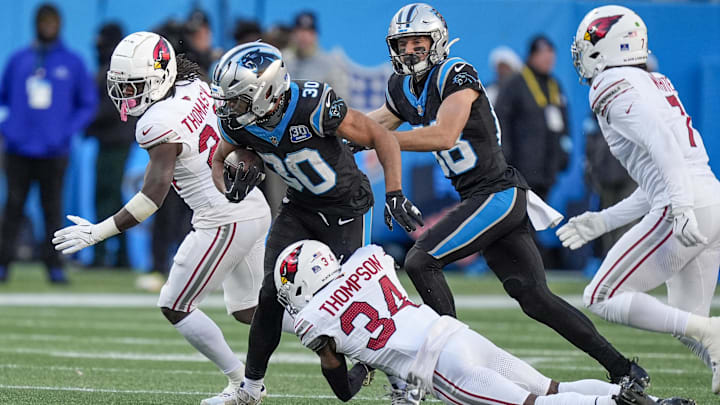 Dec 22, 2024; Charlotte, North Carolina, USA; Carolina Panthers running back Chuba Hubbard (30) is tackled but Arizona Cardinals safety Jalen Thompson (34) during the second half at Bank of America Stadium. Mandatory Credit: Jim Dedmon-Imagn Images