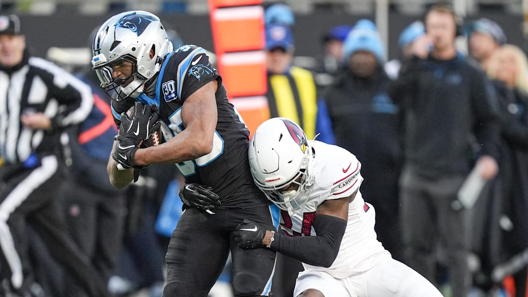 Carolina Panthers running back Chuba Hubbard tries to evade Arizona Cardinals safety Jalen Thompson.