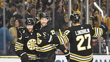 May 12, 2024; Boston, Massachusetts, USA; Boston Bruins center Pavel Zacha (18) and defenseman Hampus Lindholm (27) react with defenseman Brandon Carlo (25) after Carlos goal during the first period in game four of the second round of the 2024 Stanley Cup Playoffs against the Florida Panthers at TD Garden. Mandatory Credit: Bob DeChiara-Imagn Images