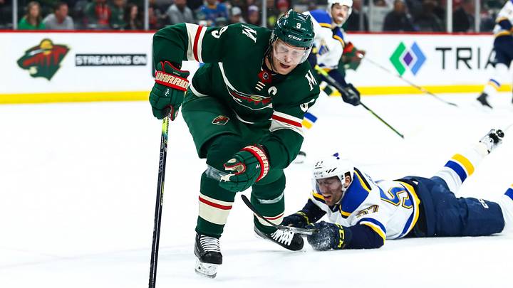 Feb 23, 2020; Saint Paul, Minnesota, USA; Minnesota Wild center Mikko Koivu (9) skates with the puck past St. Louis Blues left wing David Perron (57) in the first period at Xcel Energy Center. Mandatory Credit: David Berding-Imagn Images