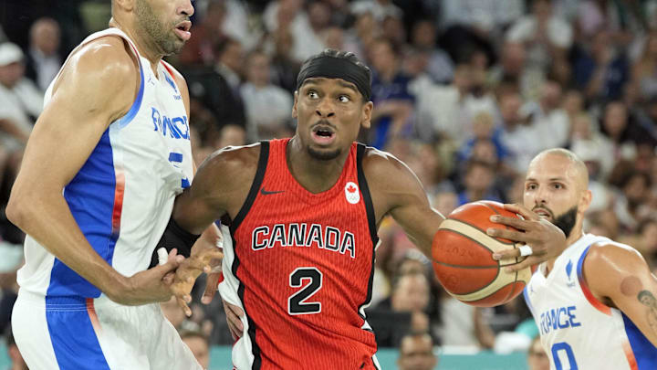 Aug 6, 2024; Paris, France; Canada guard Shai Gilgeous-Alexander (2) controls the ball against France small forward Nicolas Batum (5) and shooting guard Evan Fournier (10) in the second quarter in a men’s basketball quarterfinal game during the Paris 2024 Olympic Summer Games at Accor Arena. Mandatory Credit: Kyle Terada-USA TODAY Sports