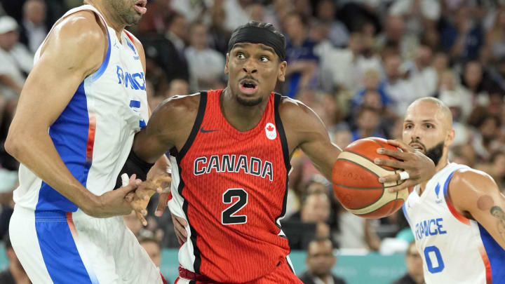 Aug 6, 2024; Paris, France; Canada guard Shai Gilgeous-Alexander (2) controls the ball against France small forward Nicolas Batum (5) and shooting guard Evan Fournier (10) in the second quarter in a men’s basketball quarterfinal game during the Paris 2024 Olympic Summer Games at Accor Arena. Mandatory Credit: Kyle Terada-USA TODAY Sports