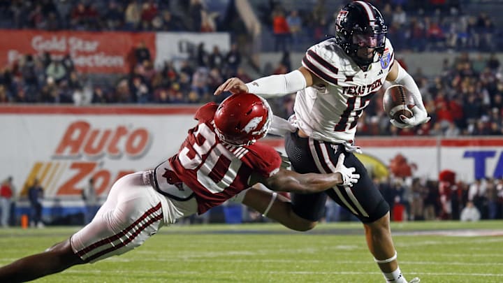 Texas Tech Red Raiders tight end Jalin Conyers (12) runs the ball for a touchdown as Arkansas Razorbacks linebacker Larry Worth III (30) attempts to make the tackle at Simmons Bank Liberty Stadium. Texas Tech Red Raiders tight end Jalin Conyers (12) runs the ball for a touchdown as Arkansas Razorbacks linebacker Larry Worth III (30) attempts to make the tackle at Simmons Bank Liberty Stadium.