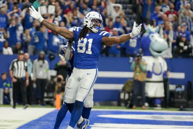 Football player Mo Alie-Cox celebrates a score in a blue jersey.