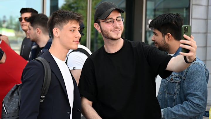 Arda Güler bir futbolseverle fotoğraf çektiriyor.