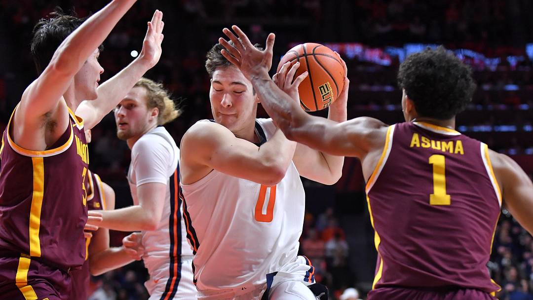 Jan 17, 2026; Champaign, Illinois, USA; Illinois Fighting Illini forward David Mirkovic (0) drives to the basket as Minnesota Golden Gophers guard Isaac Asuma (1) blocks his way during the first half at State Farm Center. Mandatory Credit: Ron Johnson-Imagn Images