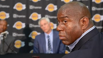 Jul 29, 2014; El Segundo, CA, USA; Magic Johnson (right) listens at a press conference with Byron Scott (left) and Los Angeles Lakers general manager Mitch Kupchak (center) at Toyota Sports Center. Mandatory Credit: Kirby Lee-Imagn Images
