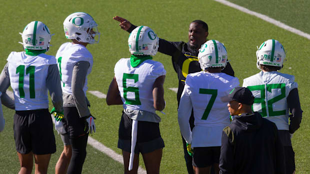 Oregon Co-Offensive Coordinator/Wide Receivers coach Junior Adams, top, directs some of the receivers during the first practi