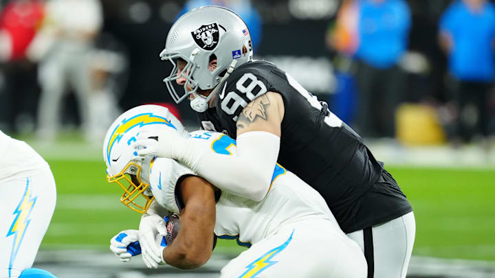 Dec 14, 2023; Paradise, Nevada, USA;  Las Vegas Raiders defensive end Maxx Crosby (98) tackles Los Angeles Chargers running back Austin Ekeler (30) in the first quarter at Allegiant Stadium. Mandatory Credit: Stephen R. Sylvanie-Imagn Images