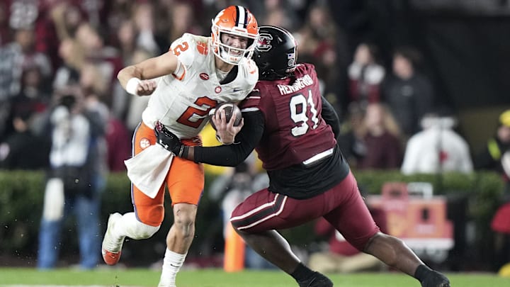Nov 25, 2023; Columbia, South Carolina, USA; Clemson Tigers quarterback Cade Klubnik (2) is tackled by South Carolina Gamecocks defensive tackle Tonka Hemingway (91) in the second half at Williams-Brice Stadium. Mandatory Credit: David Yeazell-Imagn Images