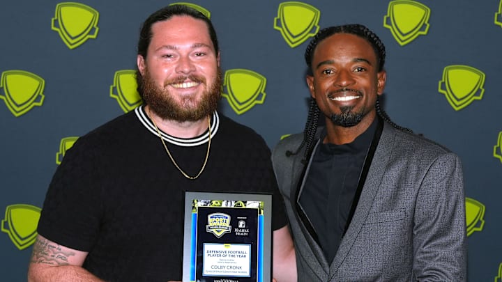Coach Daniel Fish accepts the Defensive Football Player of the Year award for Flagler Palm Coast's Colby Cronk and stands with Dee Strange-Gordon at the 2025 Volusia-Flagler High School Sports Awards Show at the Ocean Center in Daytona Beach, Monday, June 2, 2025.