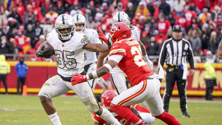 Dec 25, 2023; Kansas City, Missouri, USA; Las Vegas Raiders running back Zamir White (35) runs the ball as Kansas City Chiefs safety Mike Edwards (21) attempts the tackle during the second half at GEHA Field at Arrowhead Stadium. Mandatory Credit: Denny Medley-USA TODAY Sports