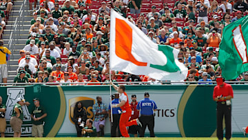 Sep 28, 2013; Tampa, FL, USA; Miami Hurricanes cheerleader runs across the field with a 'U" flag during the first half against the South Florida Bulls at Raymond James Stadium. Mandatory Credit: Kim Klement-Imagn Images