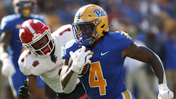 Sep 21, 2024; Pittsburgh, Pennsylvania, USA;  Pittsburgh Panthers running back Daniel Carter (4) runs past Youngstown State Penguins defensive back Stephon Hall (1) on his way to scoring a touchdown during the first quarter at Acrisure Stadium. Mandatory Credit: Charles LeClaire-Imagn Images