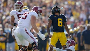 Dec 31, 2024; Tampa, FL, USA;  Alabama Crimson Tide quarterback Jalen Milroe (4) is sacked by Michigan Wolverines defensive back Brandyn Hillman (6) in the third quarter during the ReliaQuest Bowl at Raymond James Stadium. Mandatory Credit: Nathan Ray Seebeck-Imagn Images