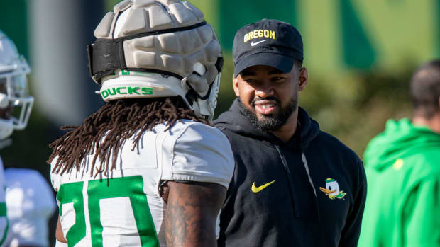 New Oregon running backs coach Ra’Shaad Samples talks with running back Jordan James during practice with the Oregon Ducks 