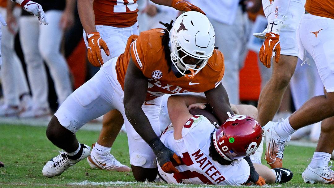 Oct 11, 2025; Dallas, Texas, USA; Texas Longhorns defensive end Brad Spence (14) sacks Oklahoma Sooners quarterback John Mateer (10) during the second half at the Cotton Bowl. Mandatory Credit: Jerome Miron-Imagn Images