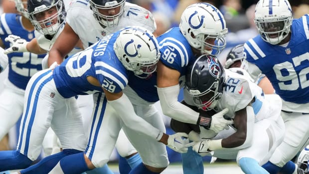 Colts defensive tackle Taven Bryan (blue jersey with white pants) helps other teammates make a tackle. 