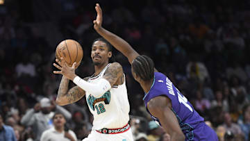 Apr 8, 2025; Charlotte, North Carolina, USA;  Memphis Grizzlies guard Ja Morant (12) looks to pass as he is defended by Charlotte Hornets forward Moussa Diabate (14) during the second half at the Spectrum Center. Mandatory Credit: Sam Sharpe-Imagn Images