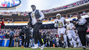 Nov 23, 2024; Kansas City, Missouri, USA;  Colorado head coach Deion Sanders leads his team on to the field against  the Kansas Jayhawks at GEHA Field at Arrowhead Stadium. Mandatory Credit: Nick Tre. Smith-Imagn Images