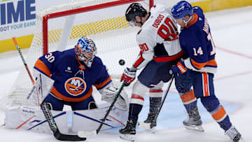 Oct 11, 2025; Elmont, New York, USA; Washington Capitals left wing Pierre-Luc Dubois (80) plays the puck against New York Islanders goaltender Ilya Sorokin (30) and center Bo Horvat (14) during the third period at UBS Arena. Mandatory Credit: Brad Penner-Imagn Images