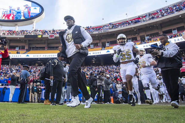 Nov 23, 2024; Kansas City, Missouri, USA;  Colorado head coach Deion Sanders leads his team on to the field against  the Kans