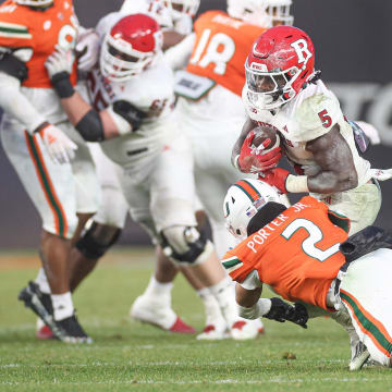 Dec 28, 2023; Bronx, NY, USA; Rutgers Scarlet Knights running back Kyle Monangai (5) is tackled by Miami Hurricanes defensive back Daryl Porter Jr. (2) during the second half of the 2023 Pinstripe Bowl at Yankee Stadium. Mandatory Credit: Vincent Carchietta-USA TODAY Sports
