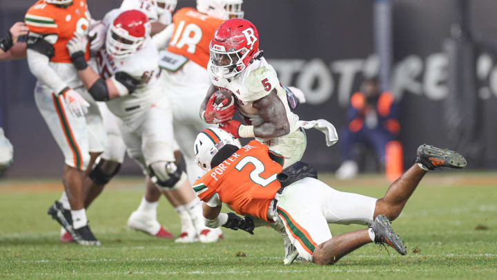 Dec 28, 2023; Bronx, NY, USA; Rutgers Scarlet Knights running back Kyle Monangai (5) is tackled by Miami Hurricanes defensive back Daryl Porter Jr. (2) during the second half of the 2023 Pinstripe Bowl at Yankee Stadium. Mandatory Credit: Vincent Carchietta-USA TODAY Sports